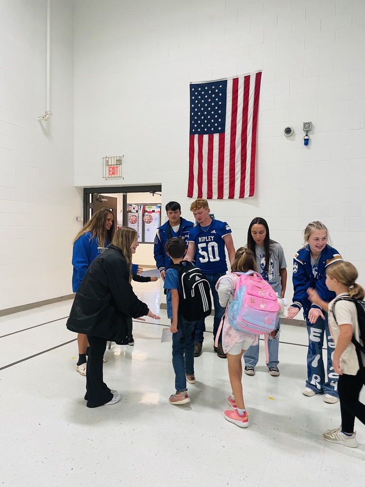 High School Football and Soccer players help kick off the day at Fairplain Elementary!